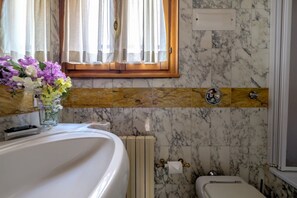 Kombination af bruser/badekar, hårtørrer, bidet, håndklæder