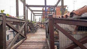 A wooden pedestrian bridge with metal railings and a metal staircase.