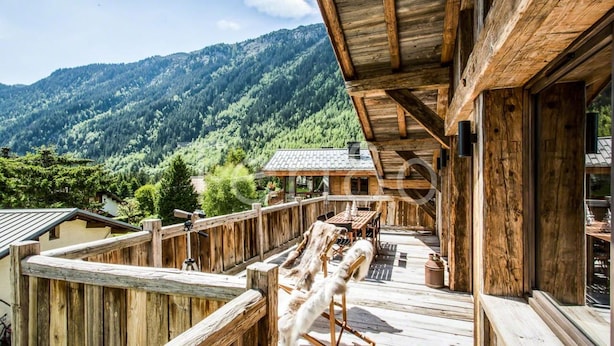 Een houten terras met uitzicht op een bergachtig landschap.