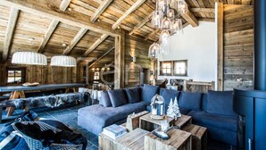 Een rustiek interieur met een houten plafond, een ruime bank en een eethoek.