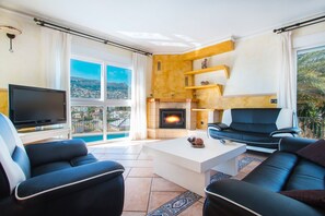 A living room with a fireplace, a television, and a sofa.