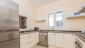 A modern kitchen with a stainless steel refrigerator, dishwasher, microwave, and oven.