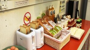 Un bufé de desayuno con pan, huevos y diferentes mermeladas.
