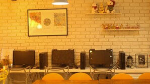 Un laboratorio de computación con varias estaciones de trabajo, una pared de ladrillo blanco y decoraciones navideñas.