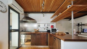 A modern kitchen with wooden cabinets, stainless steel appliances, and a built-in oven. - Rome, historic center, characteristic apartment for 6 (Roma)