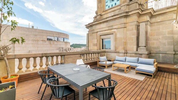 A rooftop terrace with a stone clock tower, outdoor seating, and a view of the cityscape. - Central Penthouse with terrace Plaça Catalunya I (Barcelona)