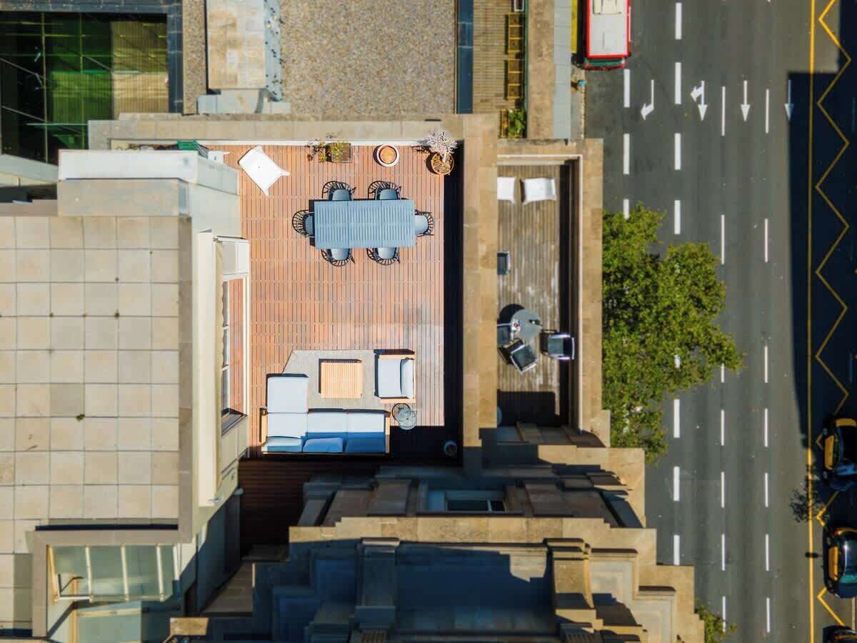 Vue aérienne d’un hôtel doté d’une terrasse sur le toit, d’une piscine et d’un parking.