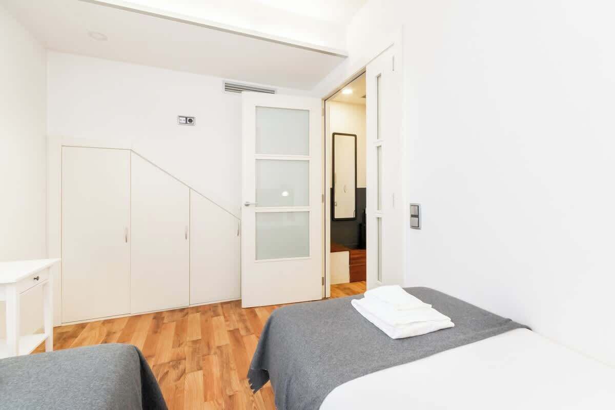 Une chambre d’hôtel avec un lit, une petite table et une armoire.