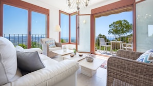 A spacious balcony with a view of the sea, furnished with a sofa, chairs, and a table. - Villa Lia - PlusHolidays (Calpe)