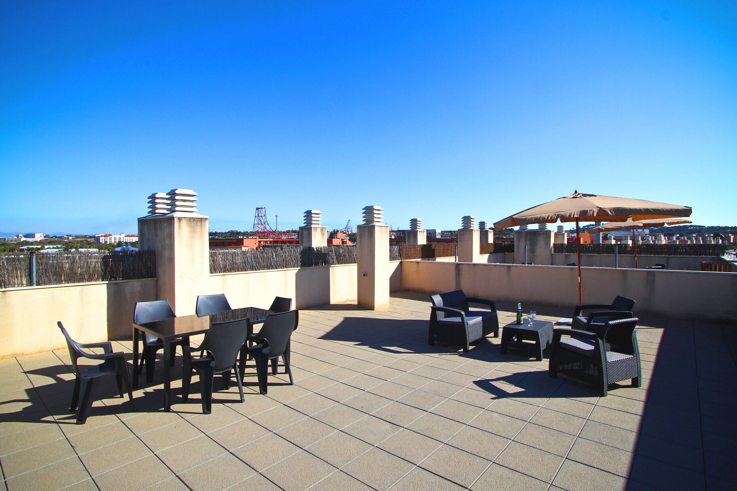 Une terrasse sur le toit, avec des sièges en plein air et une vue sur le panorama urbain.