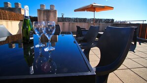 A rooftop terrace with a table set for two, featuring a bottle of champagne and two wine glasses. - Apartment with parking near PortAventura (Salou)