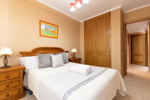Camera d'albergo con un letto grande, un armadio in legno e un quadro appeso al muro.