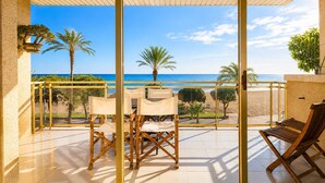 A covered outdoor seating area with a view of the beach and ocean. - GOLF SANT JORDI 2 Apartment (Cambrils)