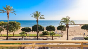 A beach view with palm trees and a bench area. - GOLF SANT JORDI 2 Apartment (Cambrils)