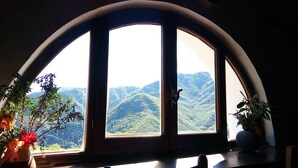 A room with a large arched window overlooking a mountainous landscape. - stone cottage, Medieval Village. 15 km Sea. Terrace (Castelvecchio di Rocca Barbena)
