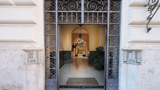 An entrance with a wrought iron gate, a central archway, and a doormat on the floor. - Domus Costanza - Bright and elegant apartment in Piazza Verbano. (Roma)