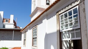 A white building with a bell tower and a window with a grid pattern. - Chiado | CHARMING & ROMANTIC | Family-Friendly (Lisboa)