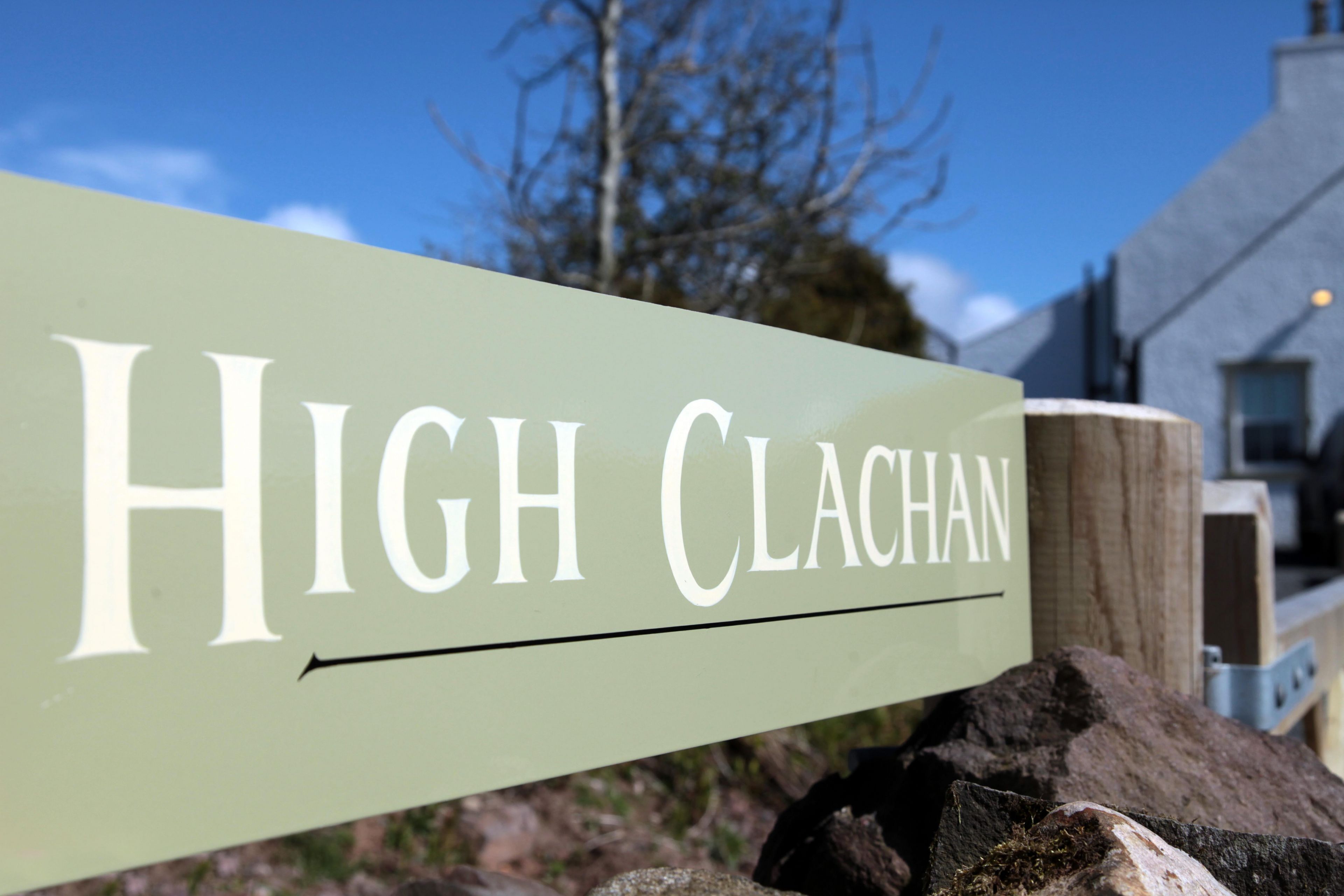 A sign with the text "High Clachan" on a wooden post.