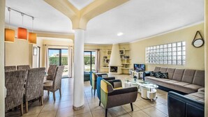 A spacious living area with a sofa, chairs, a coffee table, and a fireplace.