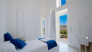 Une chambre moderne avec un lit, une vue sur l’extérieur et un escalier.
