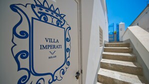 Une porte blanche avec un cadre décoratif bleu et l’inscription « VILLA IMPERATI RELAIS ».