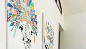 A wall with multiple artworks featuring stylized animal heads.