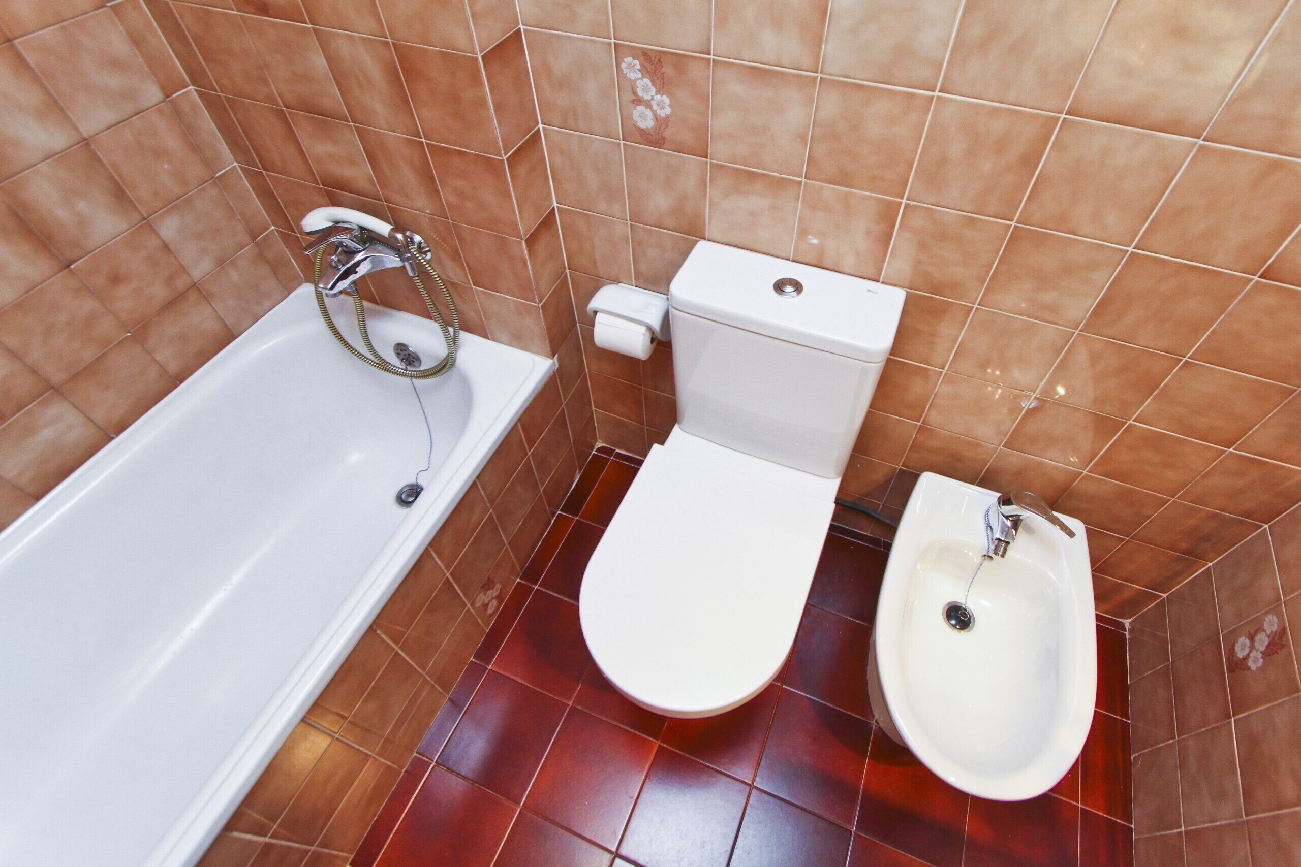 A bathroom with a bathtub, toilet, and bidet.