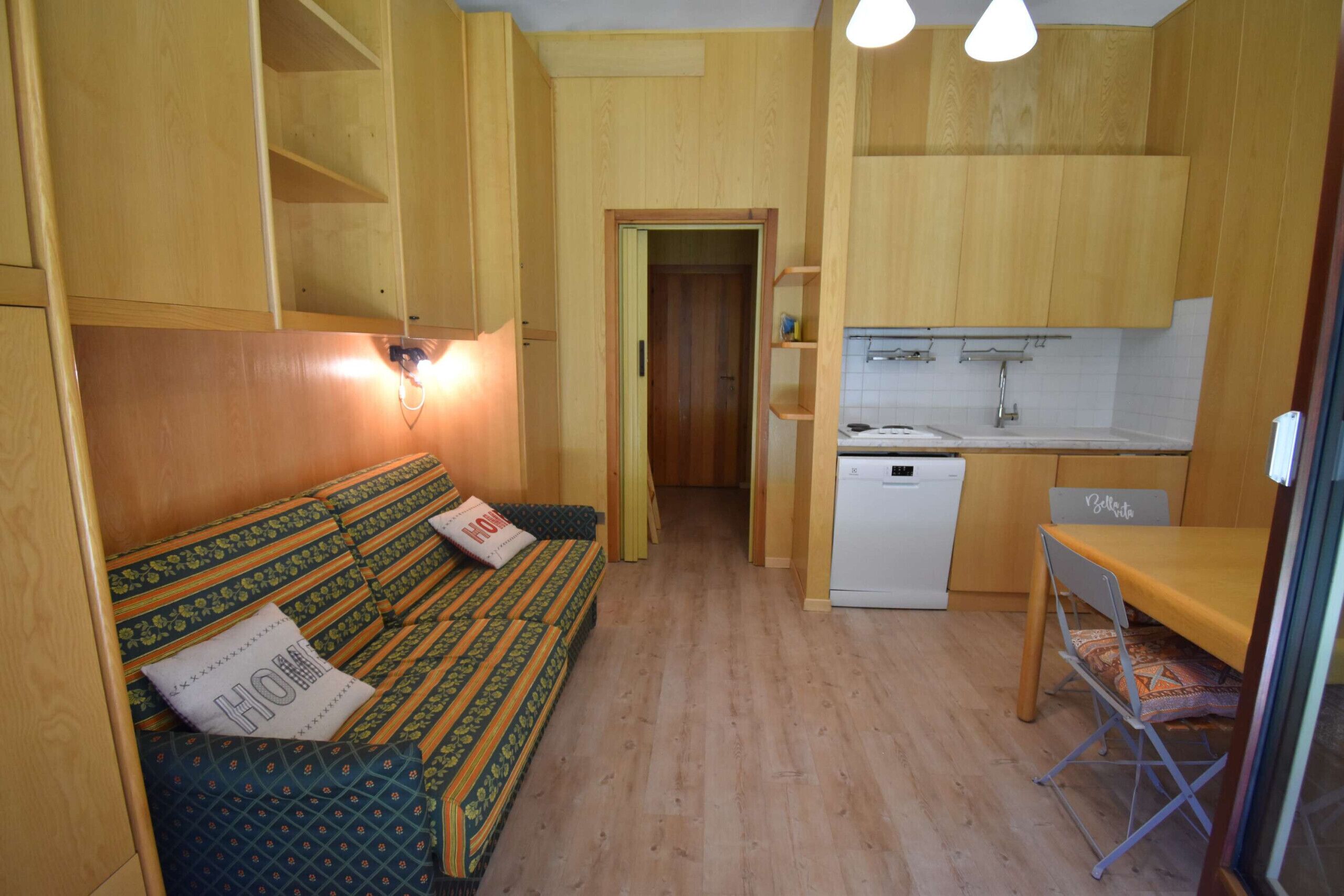Une pièce de taille modeste comprenant un lit, une petite kitchenette et un coin repas.