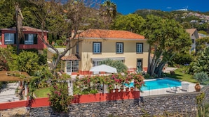 A two-story house with a swimming pool, surrounded by lush greenery and a stone wall. - Funchal Character Villa, Seaview | Quinta Alegria (Funchal)