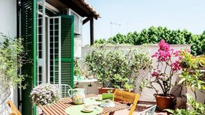 A patio with a wooden table, chairs, and potted plants. - Rome, near the Vatican, lovely apartment with terrace for 4 people (Rome)
