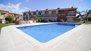 Una piscina rectangular con borde enlosado, rodeada por una zona pavimentada.