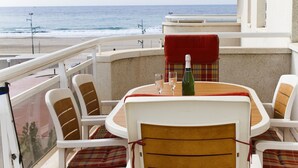 A balcony with a table set for two, featuring a bottle of champagne, two glasses, and a red cloth. - MAR PINEDA Apartment (La Pineda)