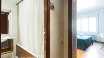 Een bad/douchecombinatie, een haardroger, handdoeken, shampoo