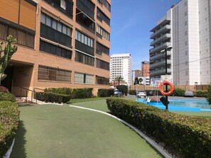A residential building with a swimming pool, surrounded by greenery and other buildings. - ALBAIDA PARK BLUELINE R014 (Benidorm)