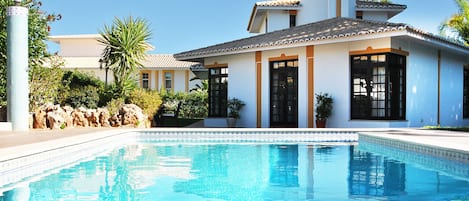 Una piscina al aire libre, una piscina climatizada