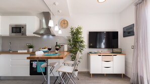 Une cuisine moderne équipée d’un four à micro-ondes, d’une cuisinière et d’un coin repas avec des chaises et une table.