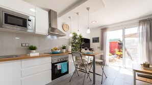 Une cuisine moderne équipée d’un four à micro-ondes, d’une cuisinière et d’un coin repas.