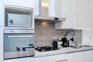 A modern kitchen with stainless steel appliances, a built-in microwave, and a gas stove.