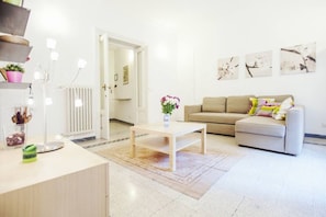 Un salon moderne avec un canapé, une table basse et des œuvres d’art accrochées au mur.