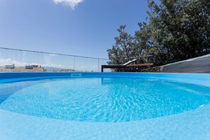 Relax by the serene pool surrounded by lush greenery and a modern slide.