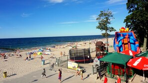 A beach with a playground, a lifeguard tower, and a Coca-Cola umbrella.