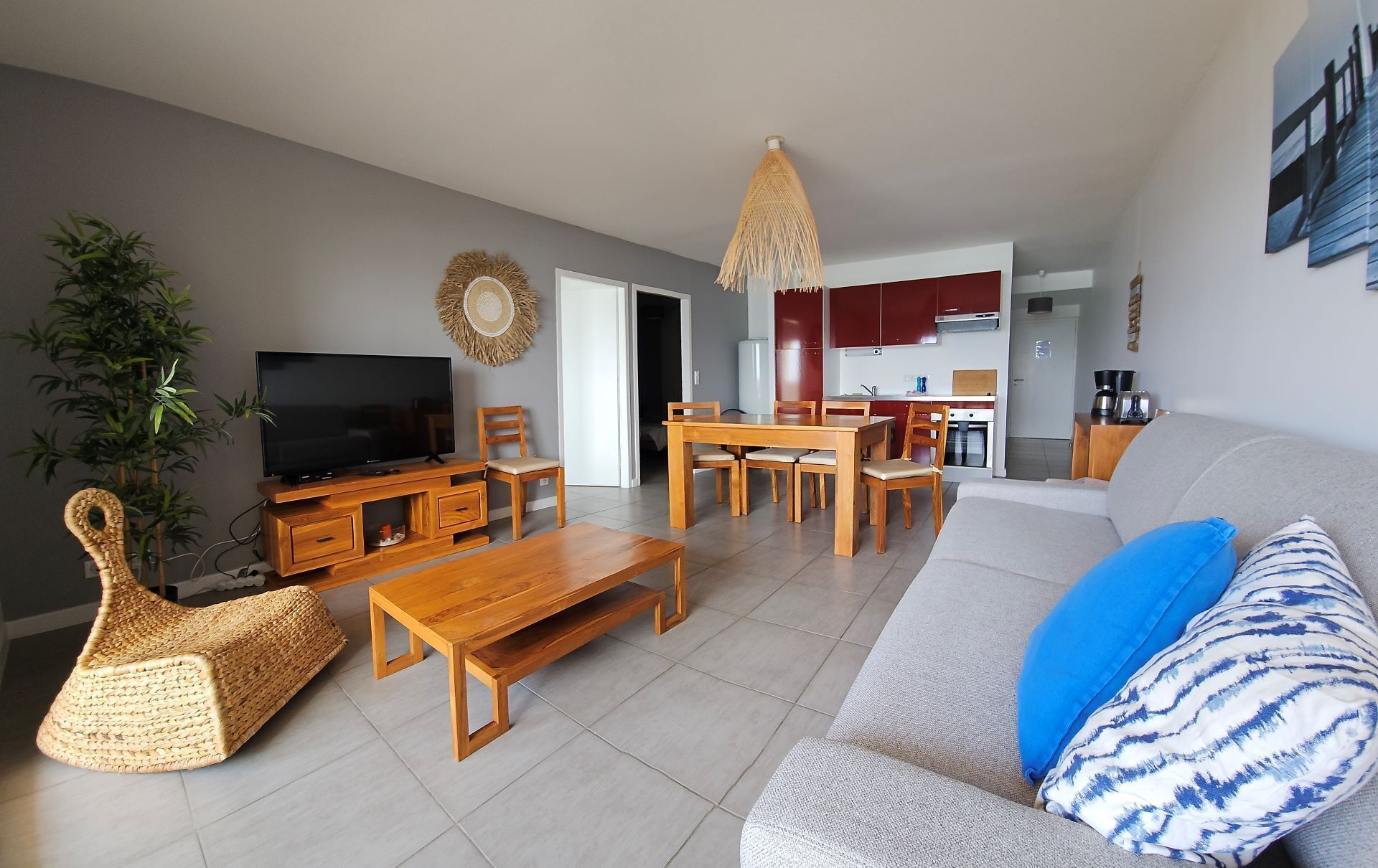 Un salon équipé d’un téléviseur, de meubles en bois, d’un canapé et d’un coin repas.