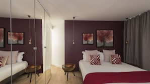 Een moderne slaapkamer met twee bedden, een groot raam en kunst aan de wanden.