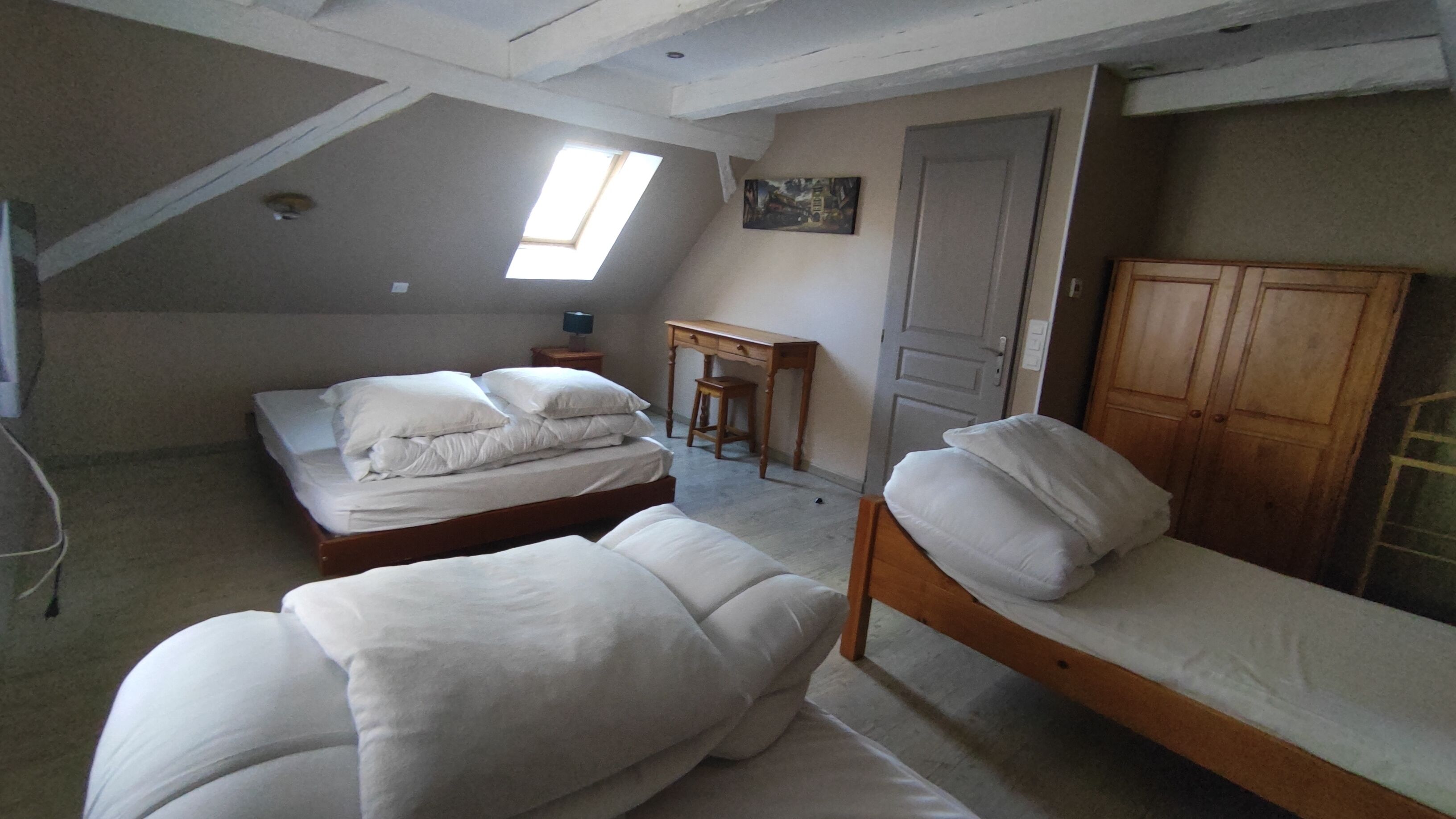 Een slaapzaal met twee bedden, een bureau, een stoel en een deur.