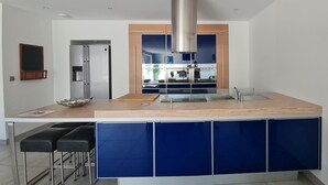 A modern kitchen with a central island, stainless steel appliances, and a large window.