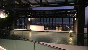 Une terrasse extérieure offrant une vue sur la ville la nuit.
