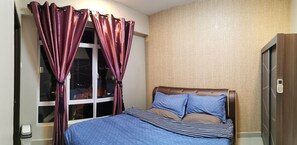 Un dormitorio con cama, cortinas, una ventana y una puerta.