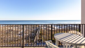Un balcon avec vue sur la plage et l’océan.