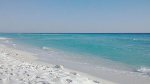 Una spiaggia con acque cristalline turchesi e sabbia bianca.