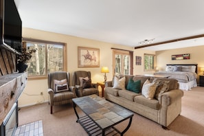 A living room with a sofa, armchair, and coffee table, a bedroom with a bed, and a dining area with a table and chairs. - Private Deck Looks Out to Courtyard, Easy Access to Shuttle to All of Resort! (Keystone)
